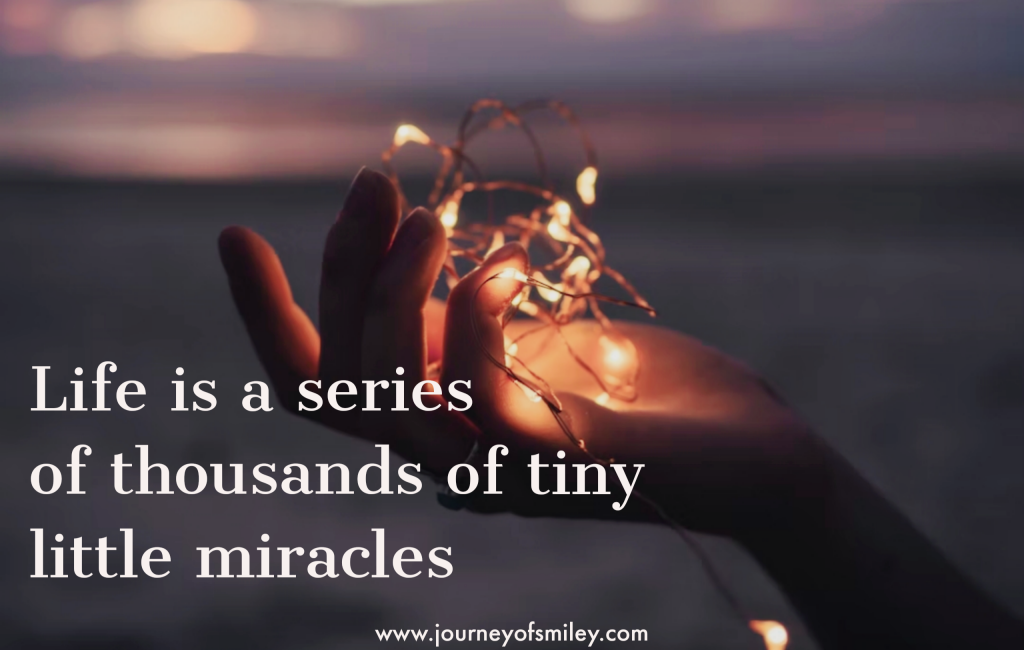 person's hand holding little shiny lights and title Life is a series of little tiny miracles on Journeyofsmiley blog