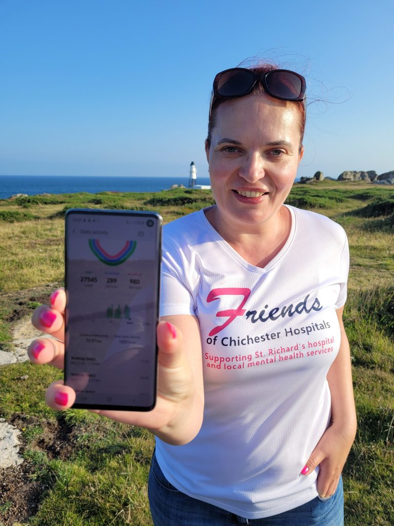 Katy holing a phone with statistics about the sponsored walk after she finished the walk around St Mary's on Scilly Isles on Journeyofsmiley blog