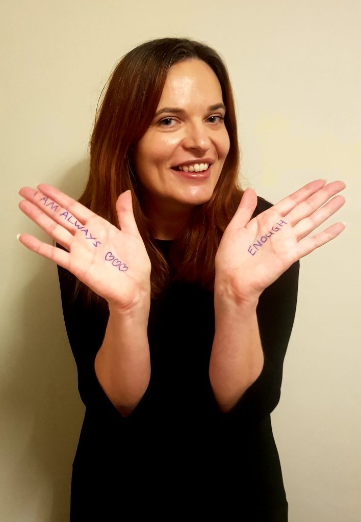 A picture of a woman with writing on her hands, I am always enough, on Journeyofsmiley Blog