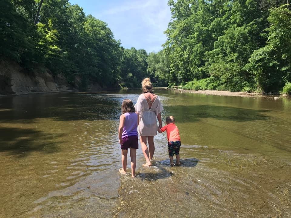 a woman with two children, with their backs front, standing in the water, nature around, woman with PTSD, a trauma survivor, on PTSD My Story Project on Journeyofsmiley blog