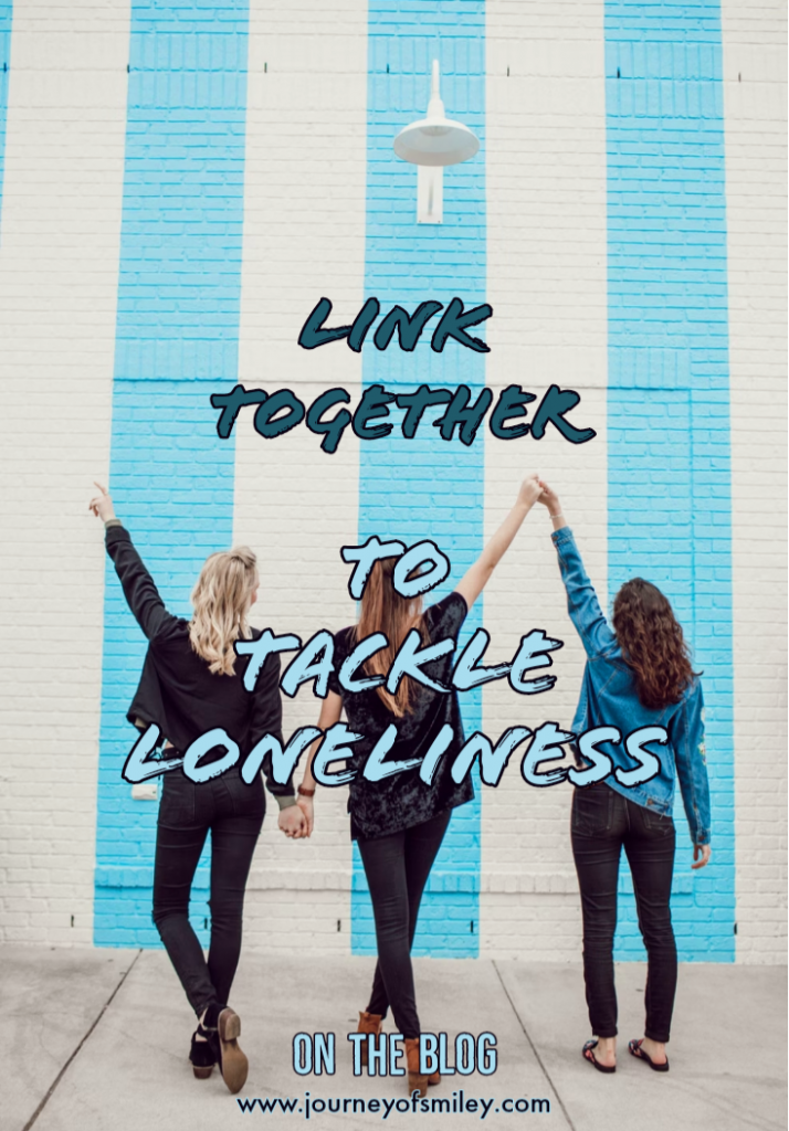 three women, standing backwards, holding hands and behind is a white and blue stripes building, and title Link together to tackle loneliness on Journeyofsmiley blog