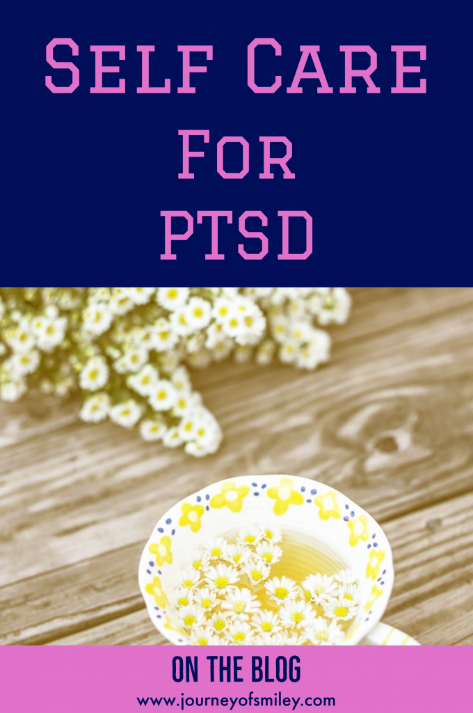 a cup with camomile tea and camomile flowers in it and next to it on a wood table with the title Self care for PTSD on Journeyofsmiley blog