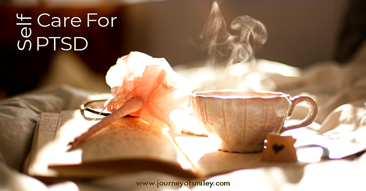 a cup of coffee or tea with a fresh smell and a dice with a heart and an orange paper rose and a book on a bed