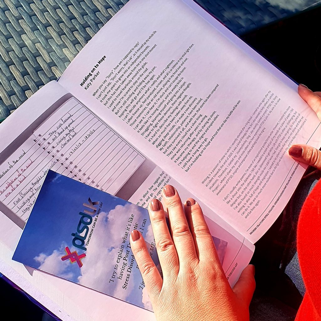 Katy holding a book with a page open on her poem, written by Katy Parker. And about how writing can help you to cope with PTSD