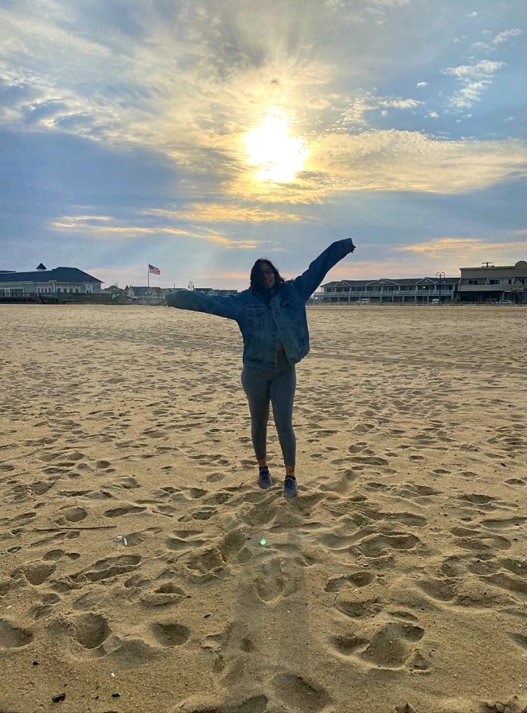 A woman on the beach standing in the sunset on the Journeyofsmiley blog. A woman trauma survivor and a warrior