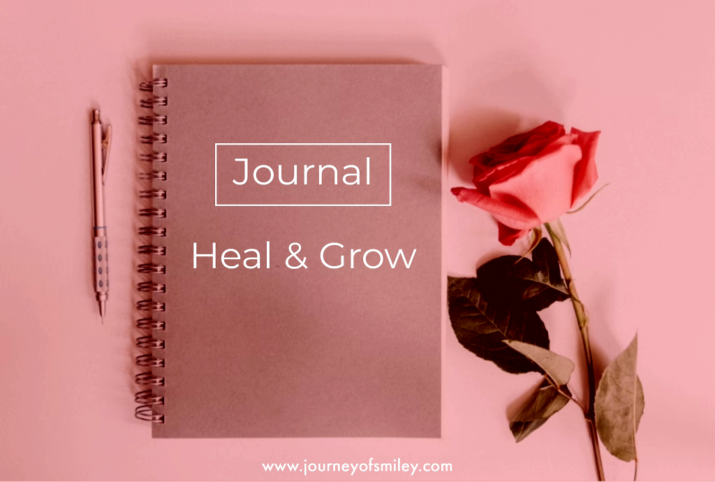 Pink background with a rose on the right side of the image and a closed notebook with a pen next to it on the title on the notebook Journaling Heal and Grow on the Journeyofsmiley blog