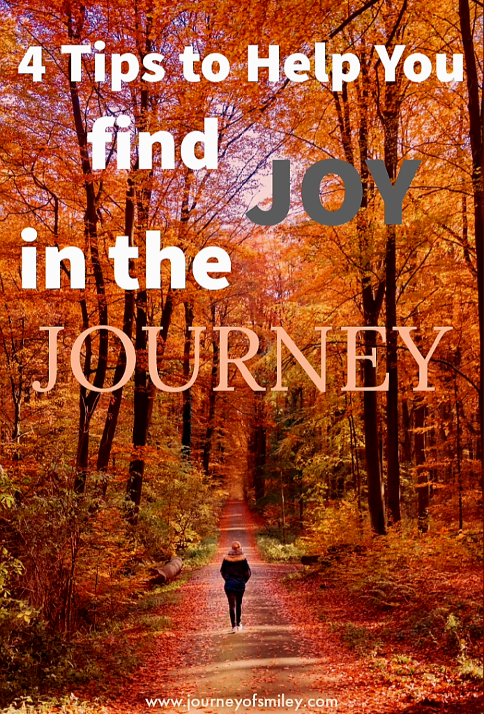 A person is walking on a path in the forest in autumn, trees have autumn colours and the title is 4 Tips to Help You find Joy in the Journey on the Journeyofsmiley blog