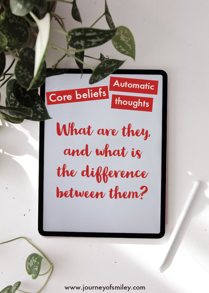 on a white service are on the left side green leaves from a green plan and in the centre is a white board with writing, 'Core beliefs' and 'Automatic thoughts' and the title What are they, and what is the difference between them? on Journeyofsmiley blog