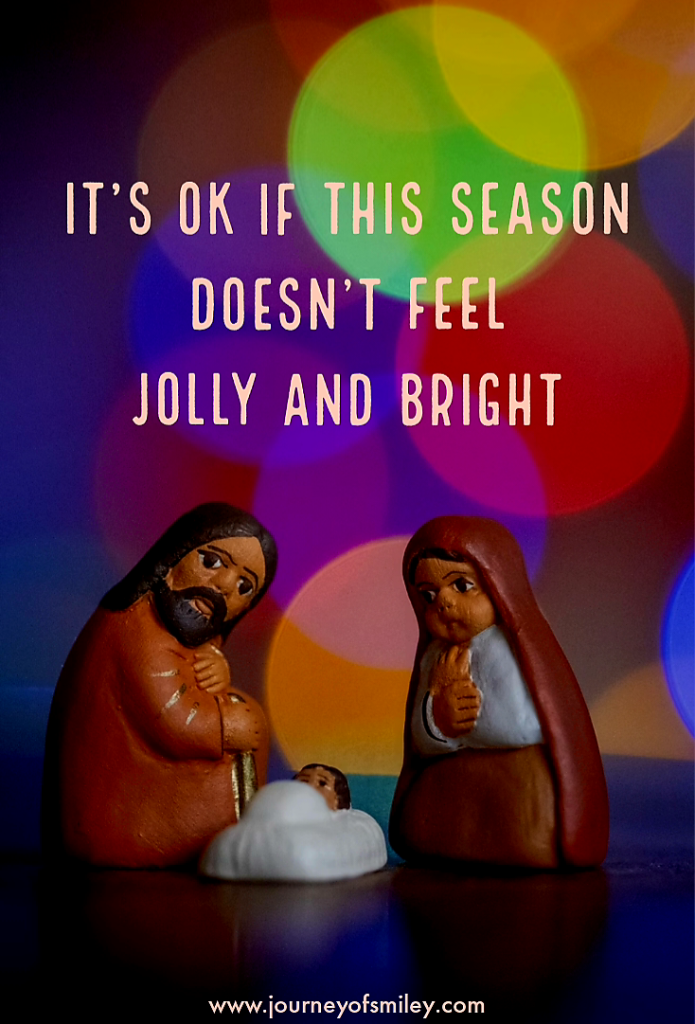 Nativity scene with lights around and the quote 'It's ok if this season doesn't feel jolly and bright' on Journeyofsmiley blog