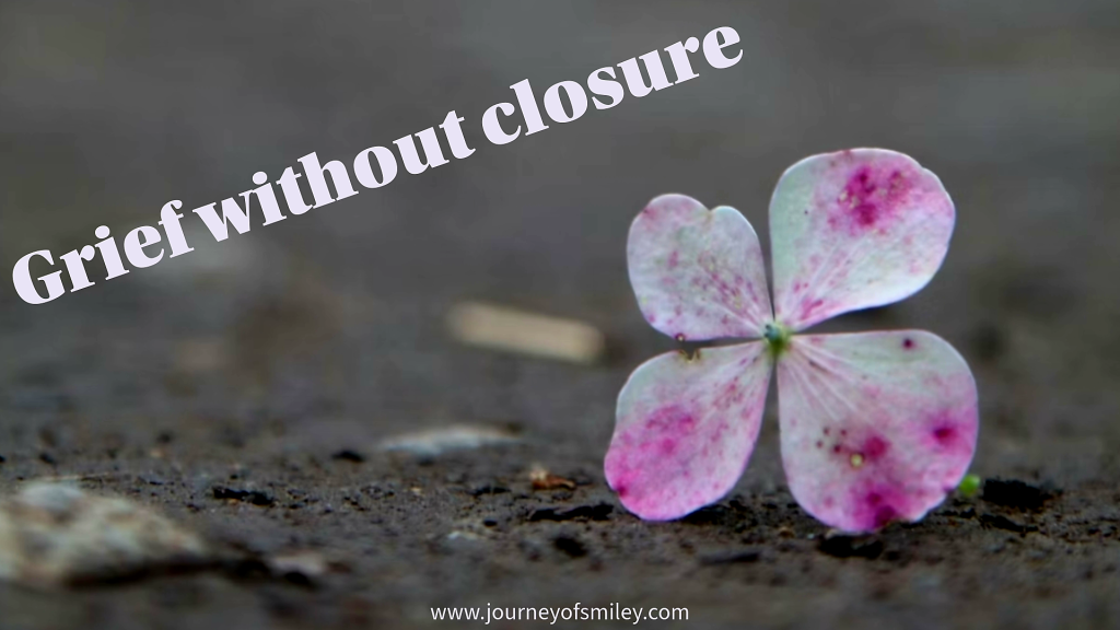 A flower buds on the ground and next to it is the title Grief without closure on Journeyofsmiley.com