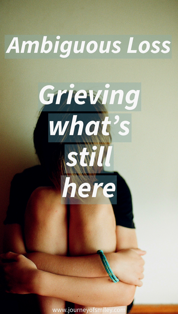 A person sitting on the floor, with bended legs, holding around knees with their arms, and the title is Ambiguous Loss Grieving what's still there on Journeyofsmiley.com 