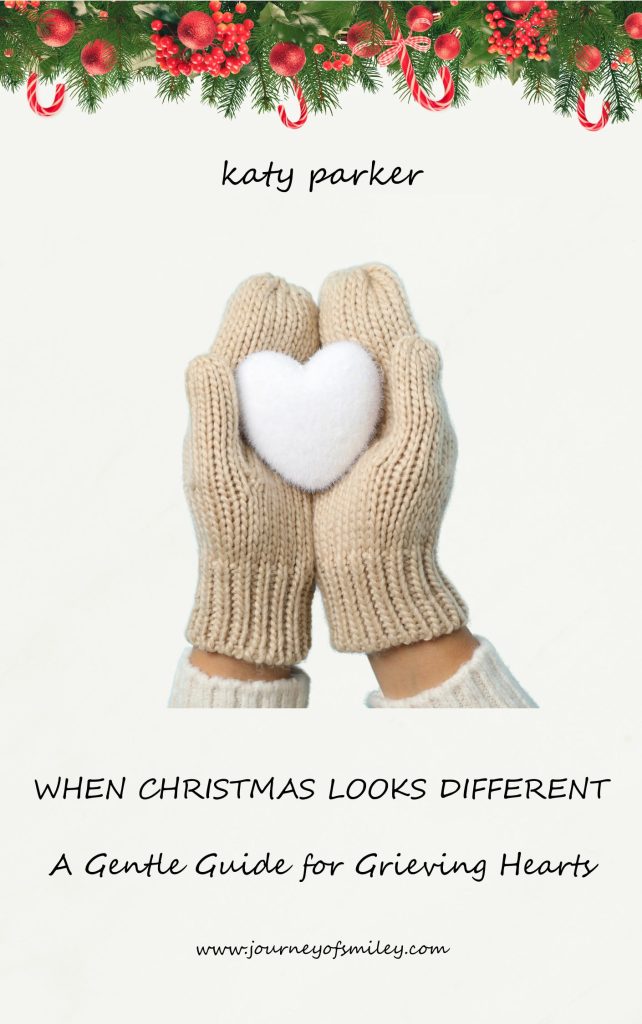 Christmas decoration on the top, and below are two hands in gloves together, holding a snow heart, and above is the author's name Katy Parker and below the title When Christmas Looks Different, A Gentle Guide for Grieving Hearts on Journeyofsmiley.com 