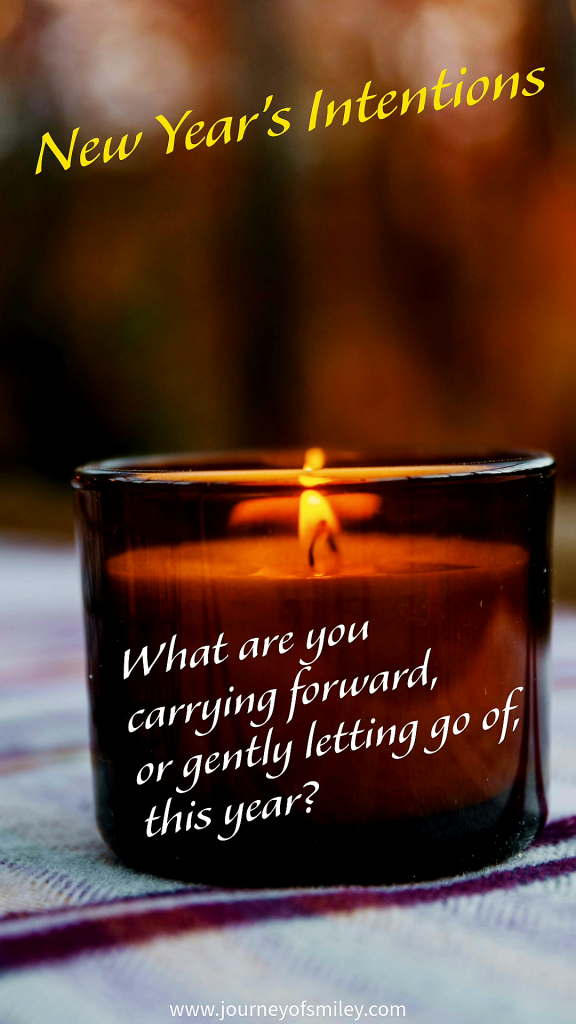 A lit candle on a table, with the title above it New Year's Intentions and on the candle is written, What are you carrying forward, or gently letting go of, this year? on Journeyofsmiley blog