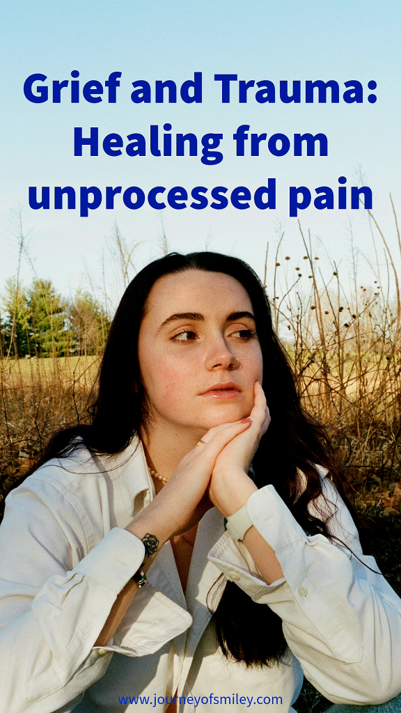 A woman in while jacket sitting in nature, behind her are trees in the background and yellow grass, some long grass, and above her is the title Grief and Trauma, Healing from unprocessed pain on Journeyofsmiley blog